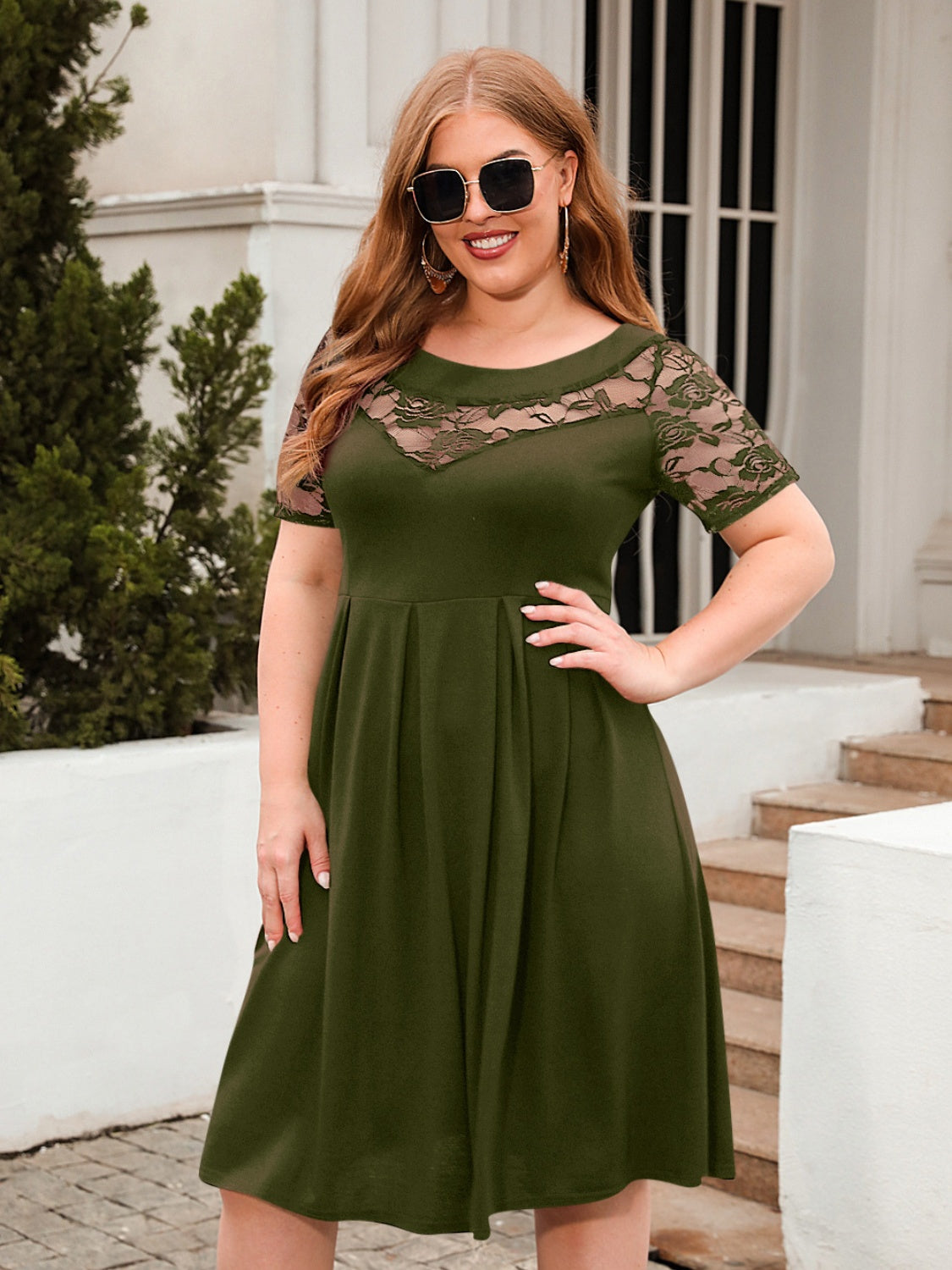 Plus size olive green ruched dress with lace short sleeves and round neck, knee-length, worn by woman with sunglasses outdoors