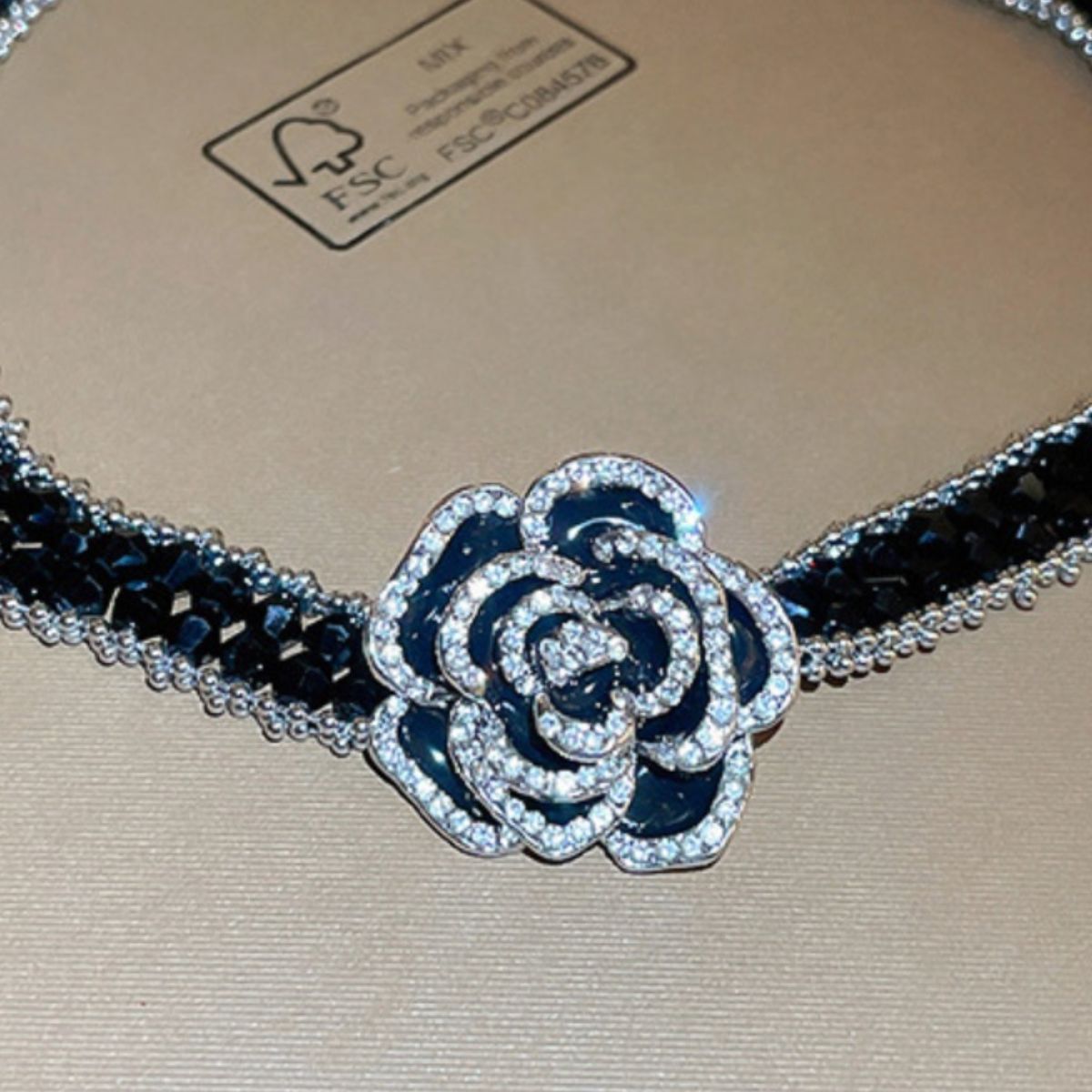 Alloy flower statement necklace with sparkling crystals and black beaded chain by Trendsi