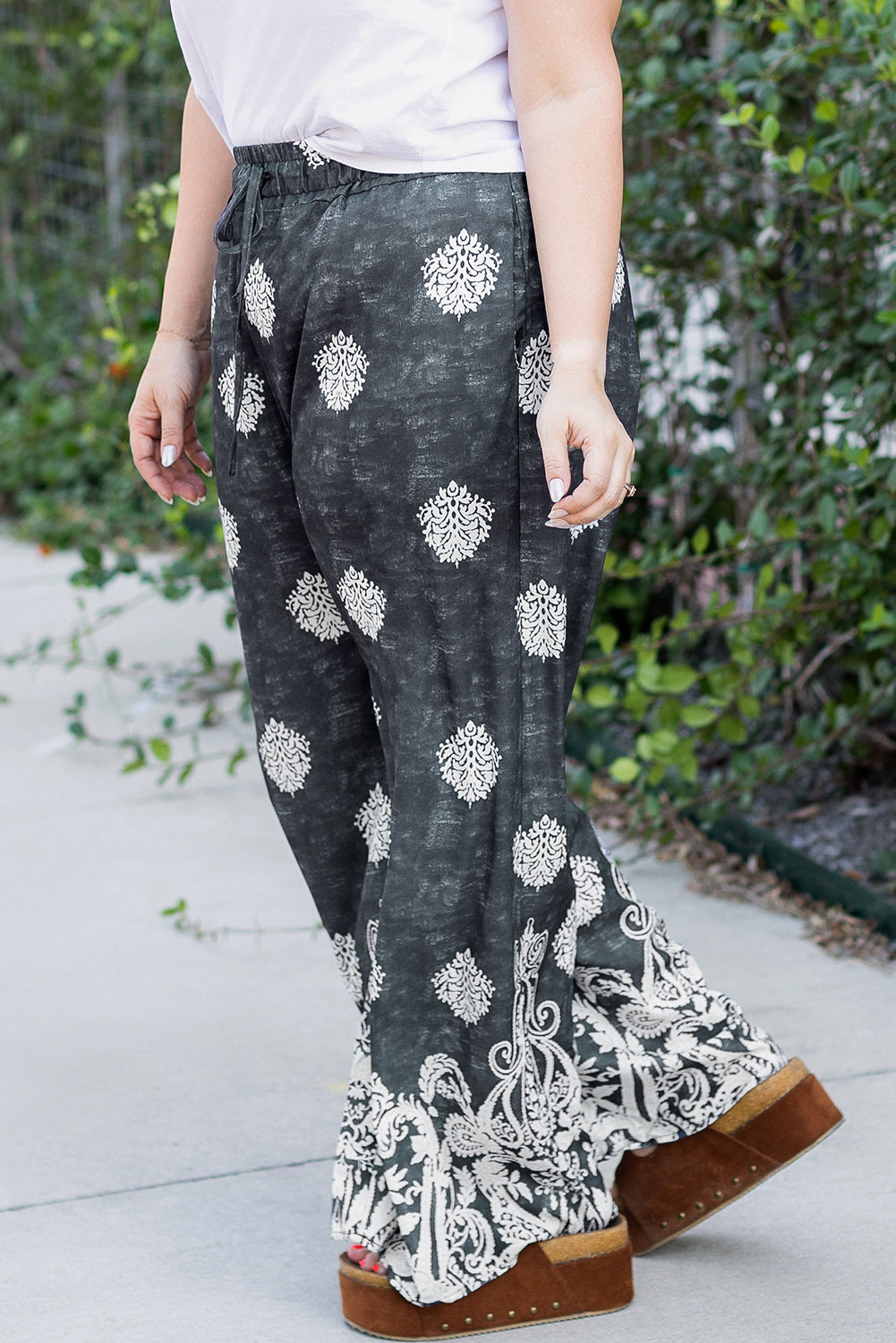 Comfortable plus size lounge pants with black and white intricate patterns worn outdoors