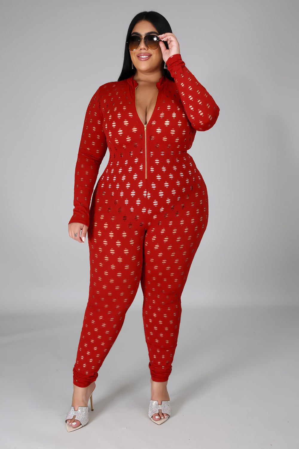 Curvy women zip front jumpsuit in red with long sleeves and printed pattern styled with sunglasses and heels