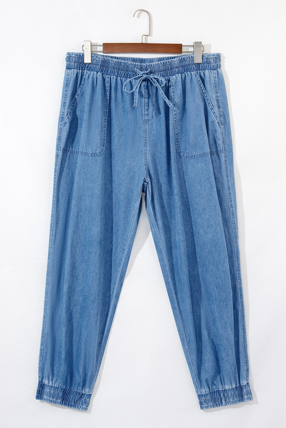 Light blue drawstring waist plus size jeans with elastic cuffs and front pockets