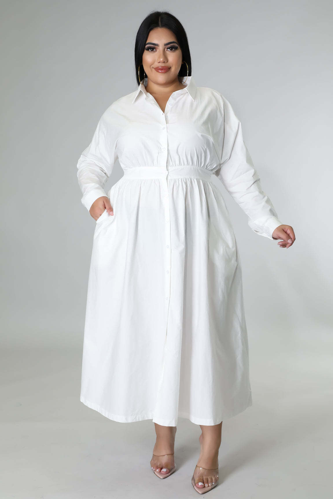Plus size woman wearing a white shirt dress with pockets, a fashionable plus size dresses for women