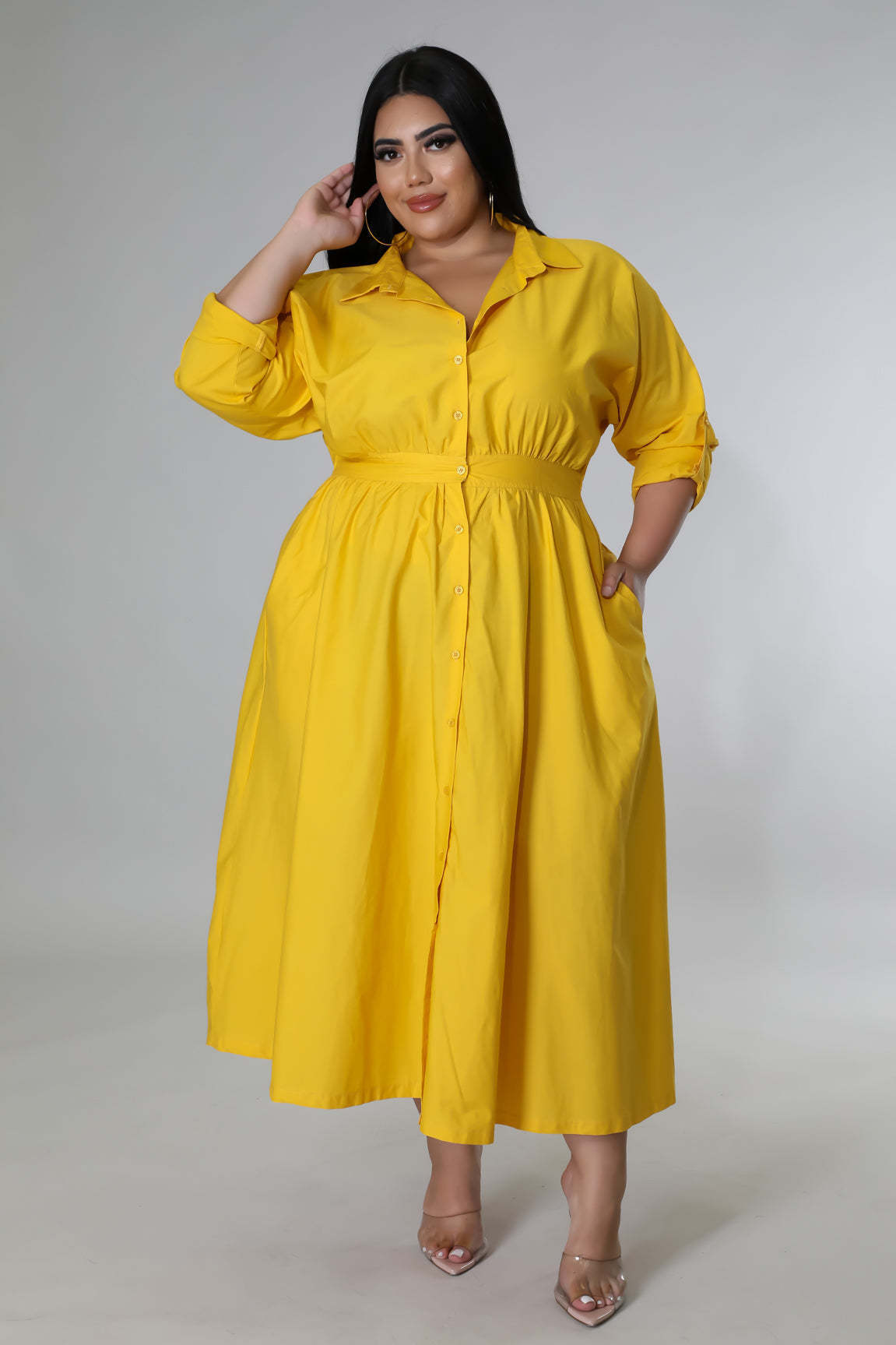 Woman wearing a yellow fashionable plus size dresses for women with button-down front and pockets