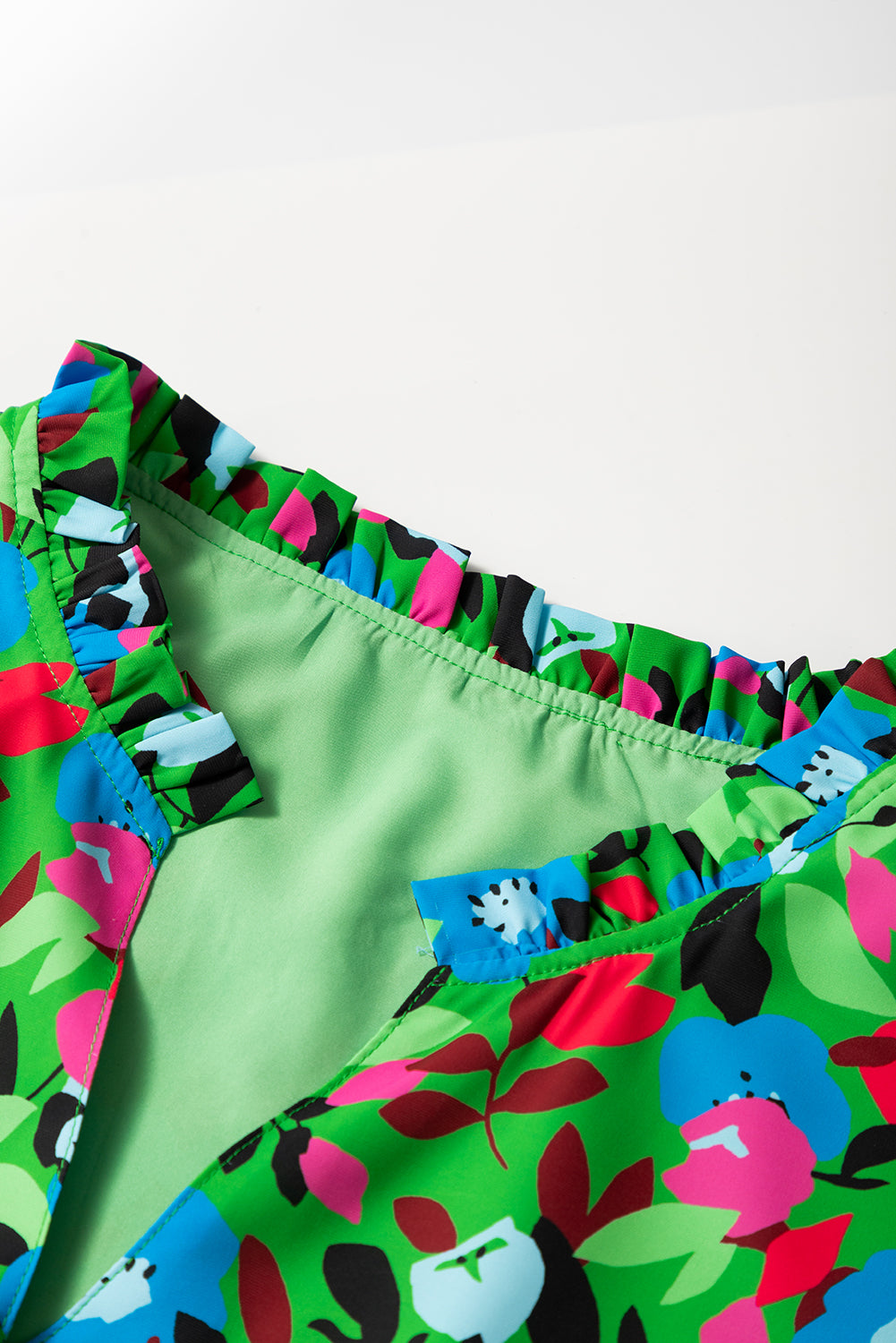 Close-up of kjplussizefashion floral print plus size blouse with vibrant multicolor ruffled neckline