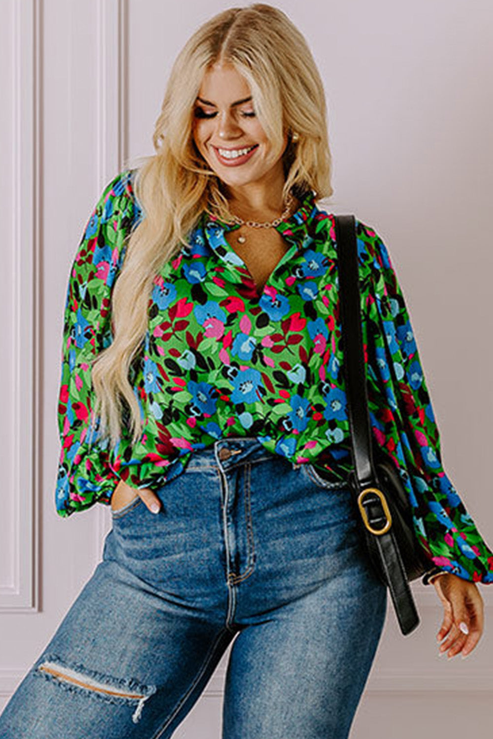 Floral print plus size blouse with vibrant blue and green flowers worn with high-waisted distressed jeans
