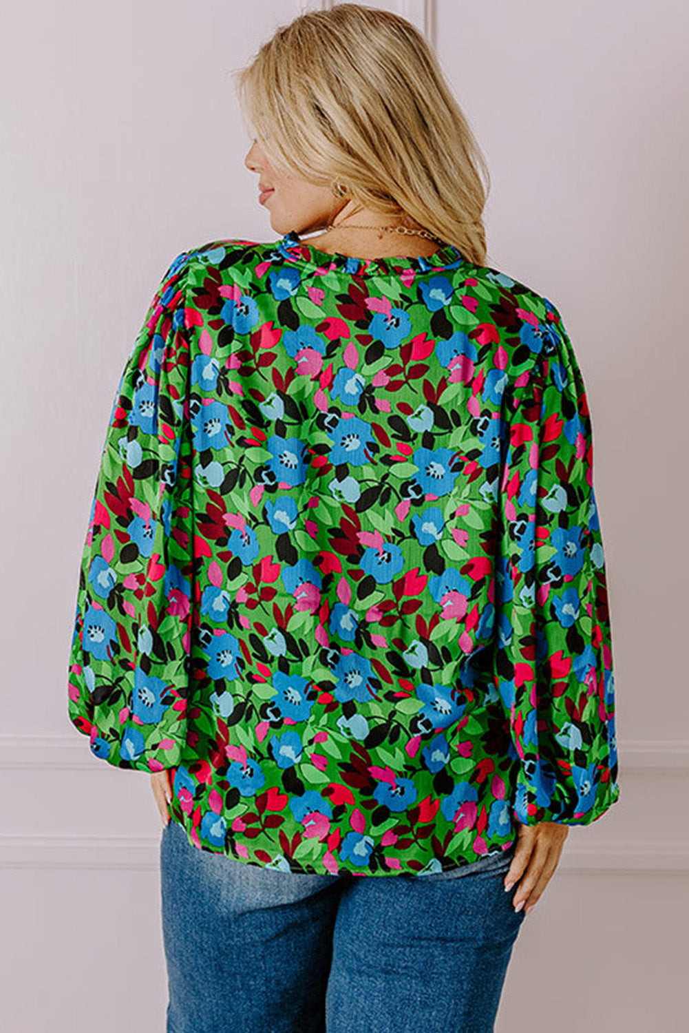 Back view of a woman wearing a vibrant floral print plus size blouse with long puff sleeves