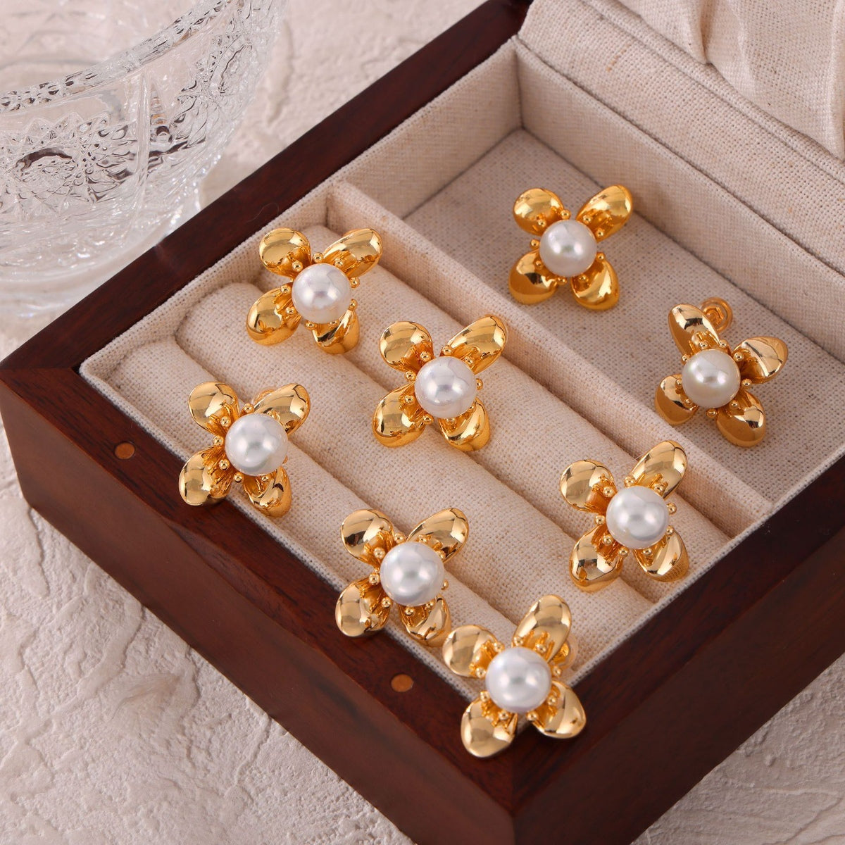 Trendsi synthetic pearl titanium earrings with gold flower design in a wooden jewelry box