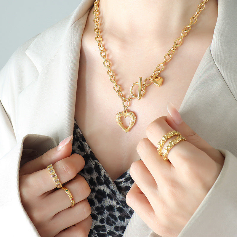 Trendsi gold titanium steel heart necklace with chunky chain worn with stylish rings and blazer