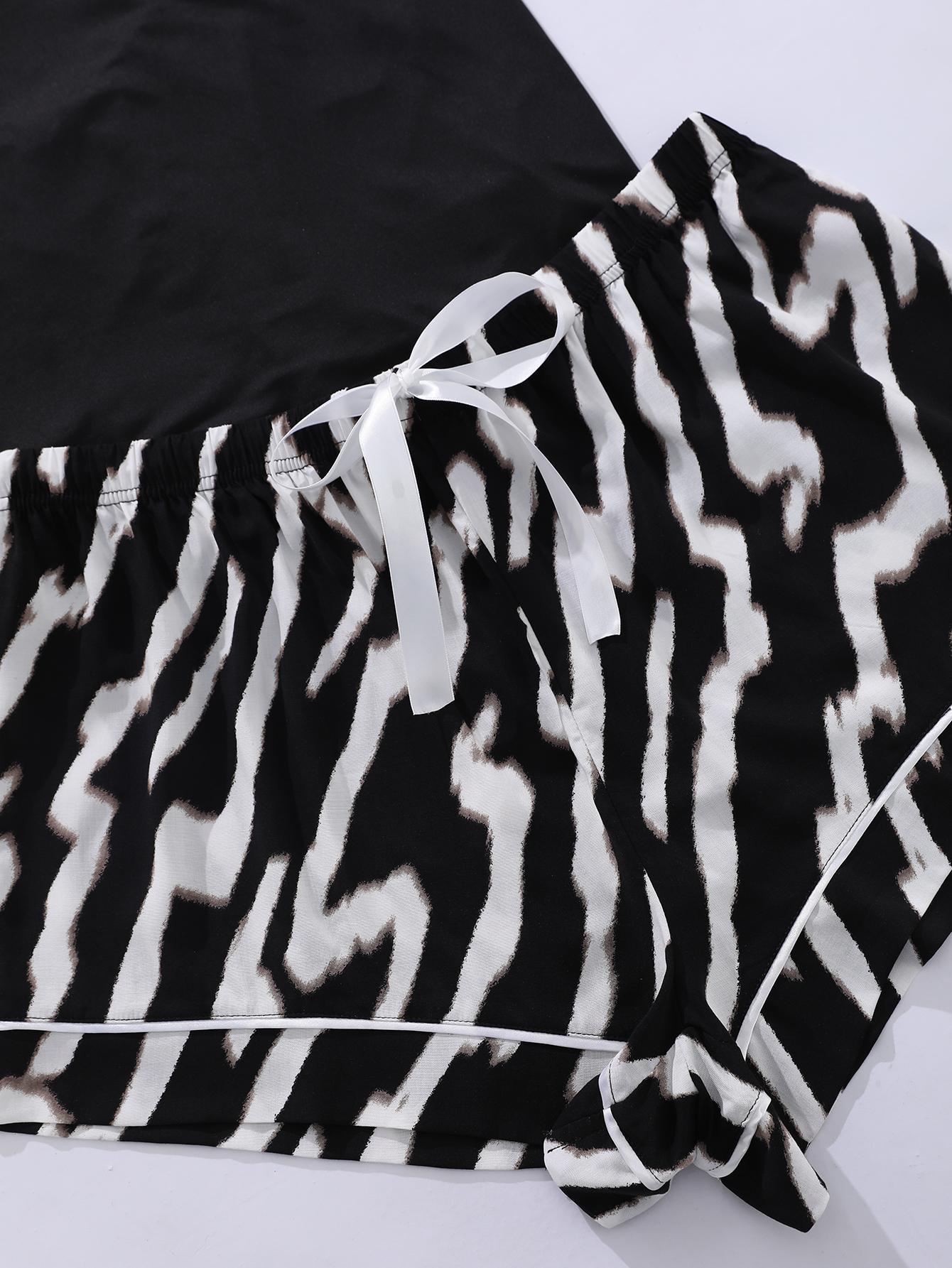 Close-up of lace trim plus size sleepwear shorts with black and white zebra print and white ribbon bow