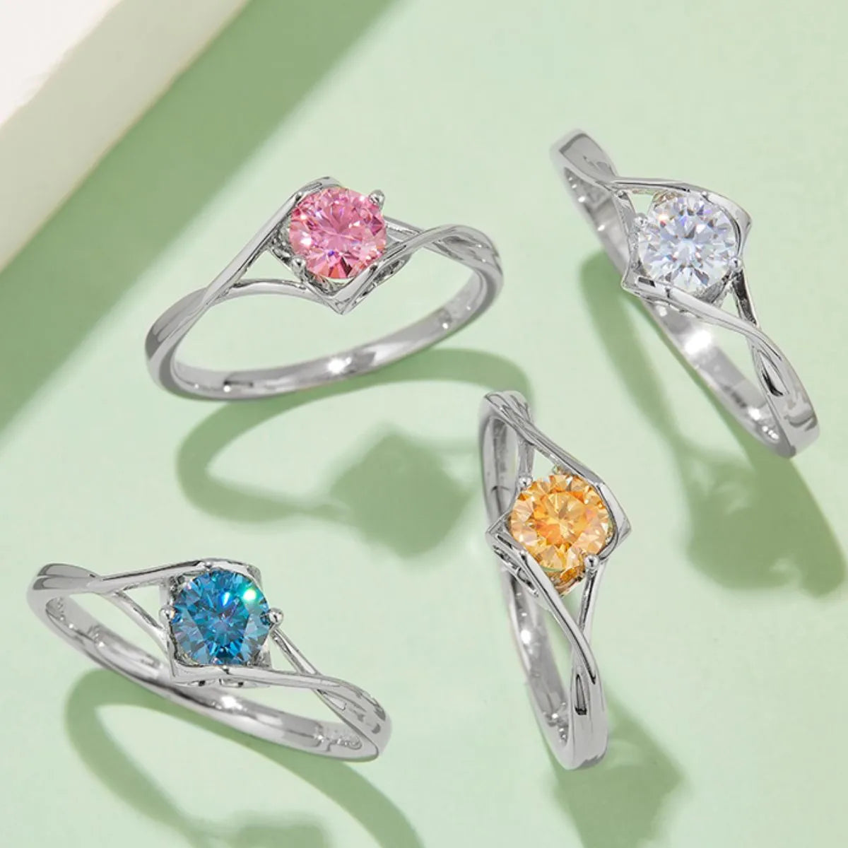 Moissanite sterling silver ring set with pink, clear, blue, and yellow stones in elegant designs