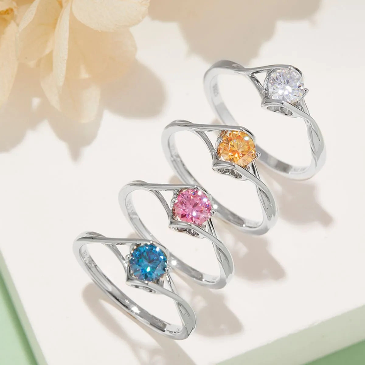 Moissanite sterling silver ring collection with vibrant blue, pink, orange, and clear stones on delicate bands