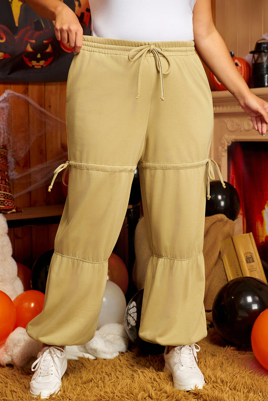 Plus size beige drawstring pants with elastic waist and adjustable ties on kjplussizefashion model