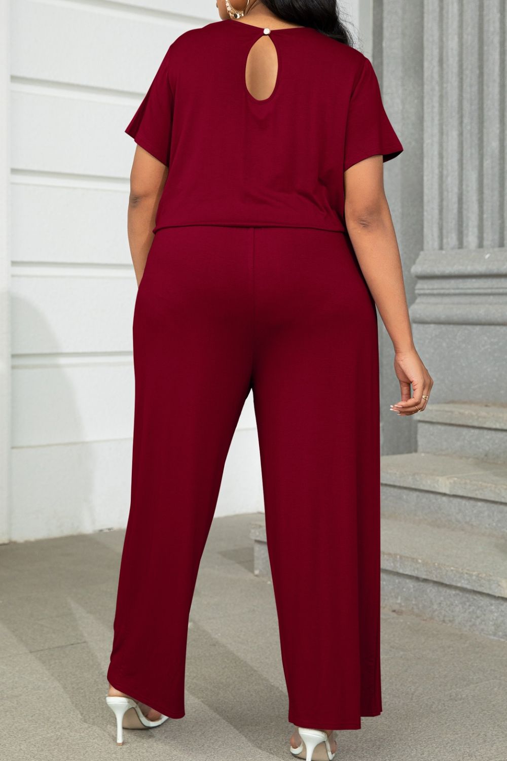 Back view of plus size casual jumpsuit in burgundy with short sleeves and keyhole detail