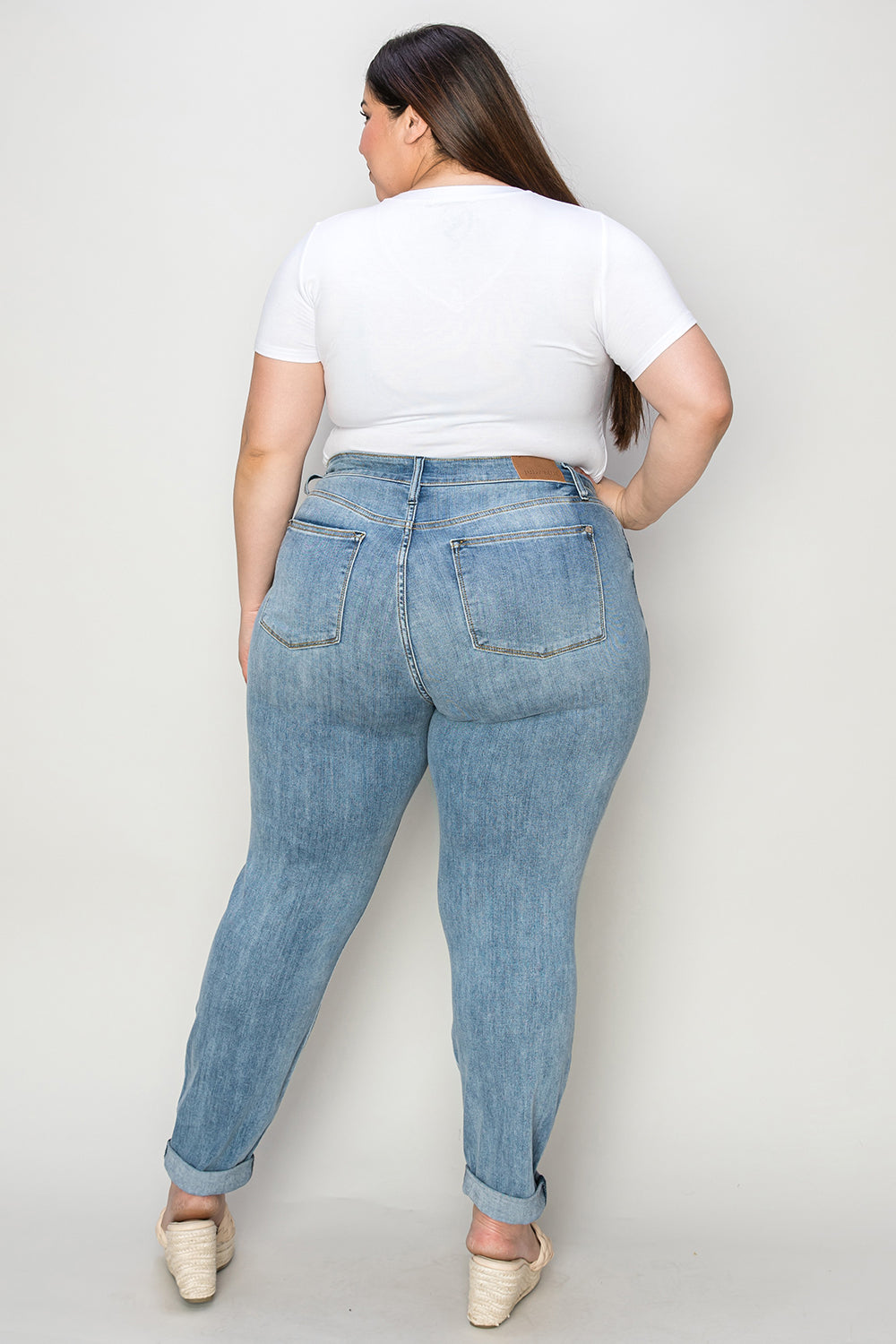 Plus size cuffed hem jeans in light wash denim worn by model with white top and beige shoes