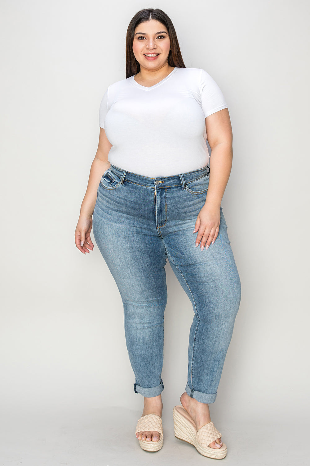 Plus size model wearing plus size cuffed hem jeans with white t-shirt and sandals
