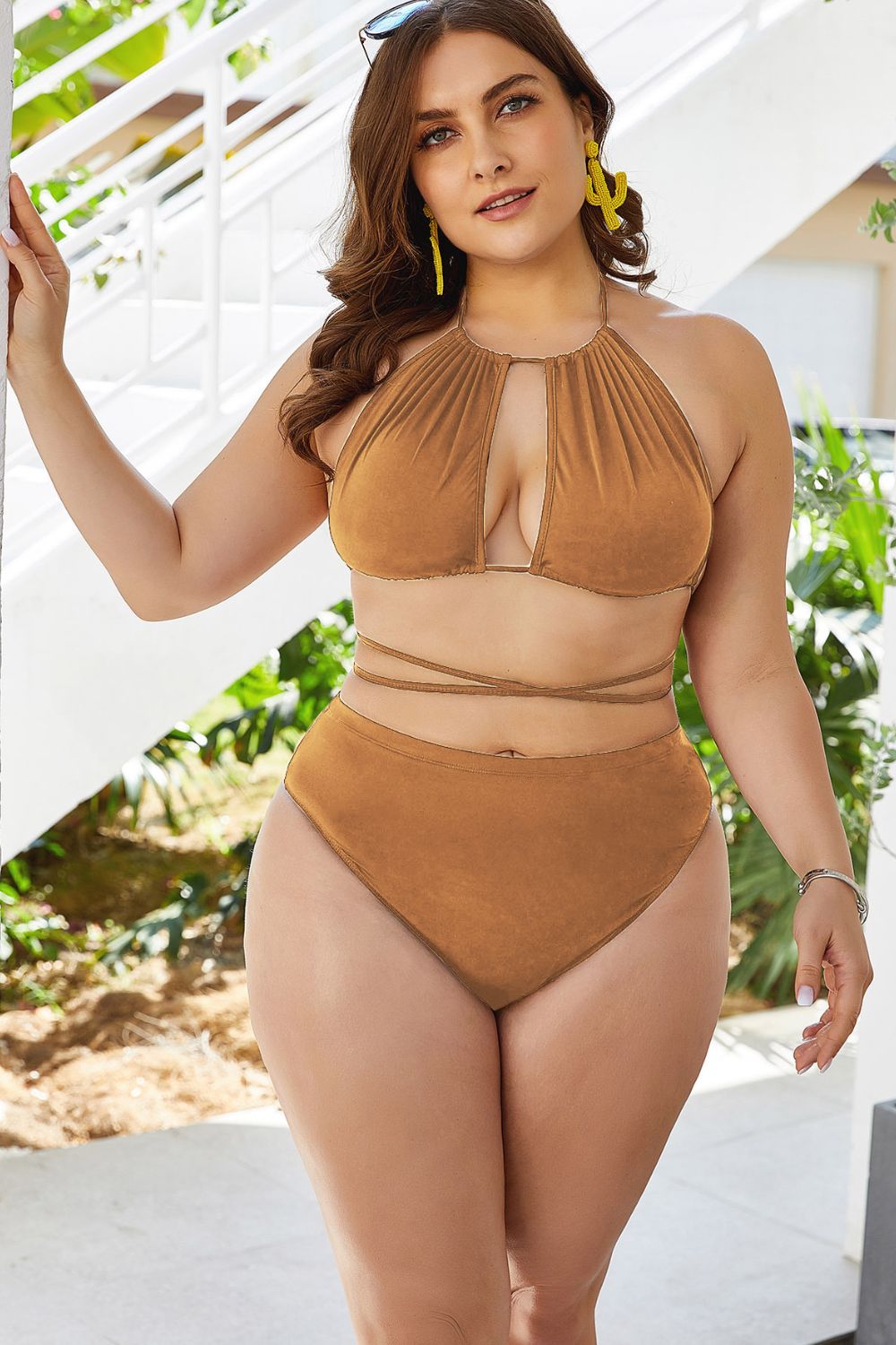 Confident woman wearing a brown plus size cutout bikini set with wrap-around straps outdoors