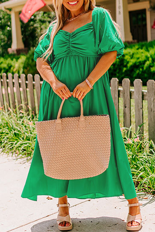Plus size green puff sleeve dress worn with beige woven tote bag and sandals outdoors