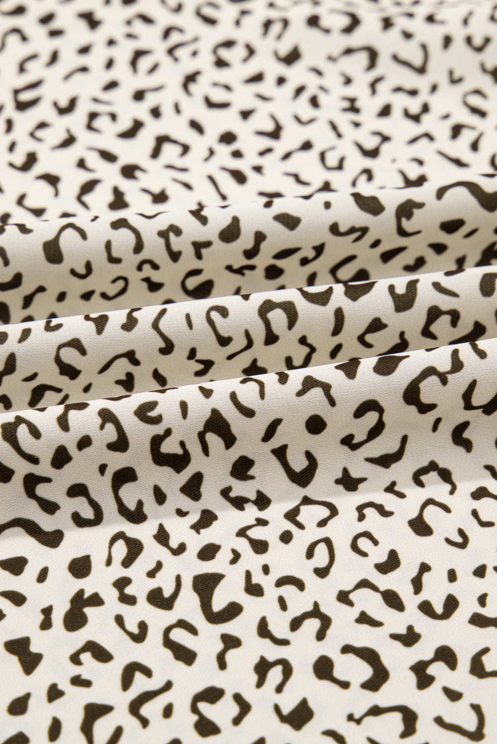 Close-up of fabric featuring black and white plus size leopard print dress pattern from kjplussizefashion