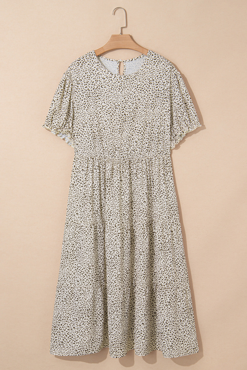 Plus size leopard print dress midi length with short sleeves and flowy skirt hanging on wooden hanger