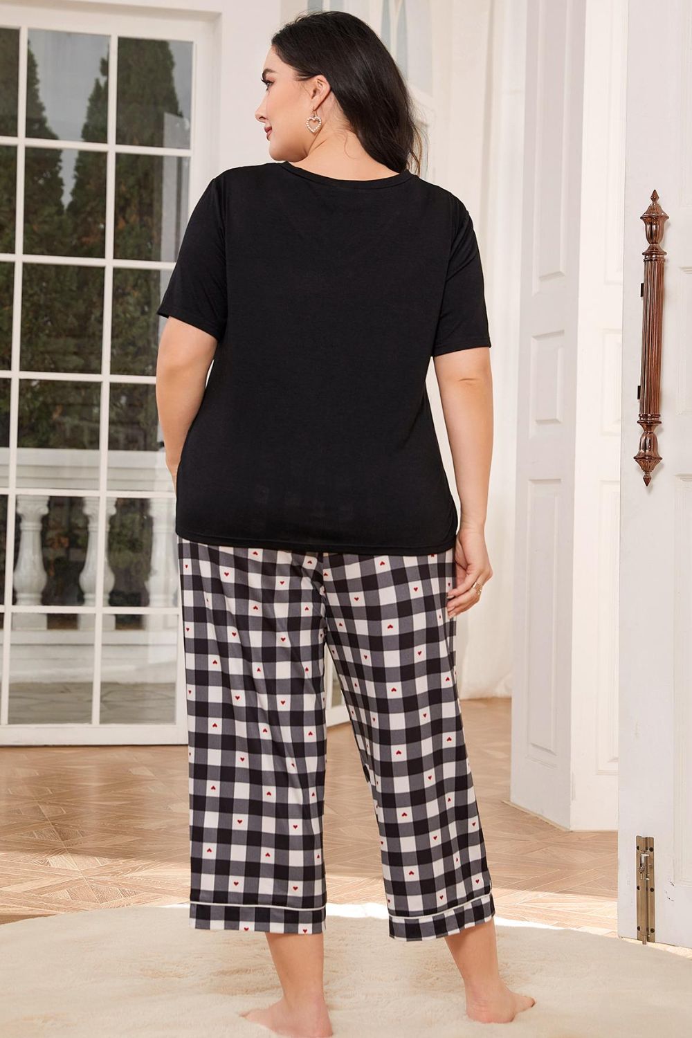 Plus size lounge set for women featuring a black short sleeve top and checkered wide-leg pants