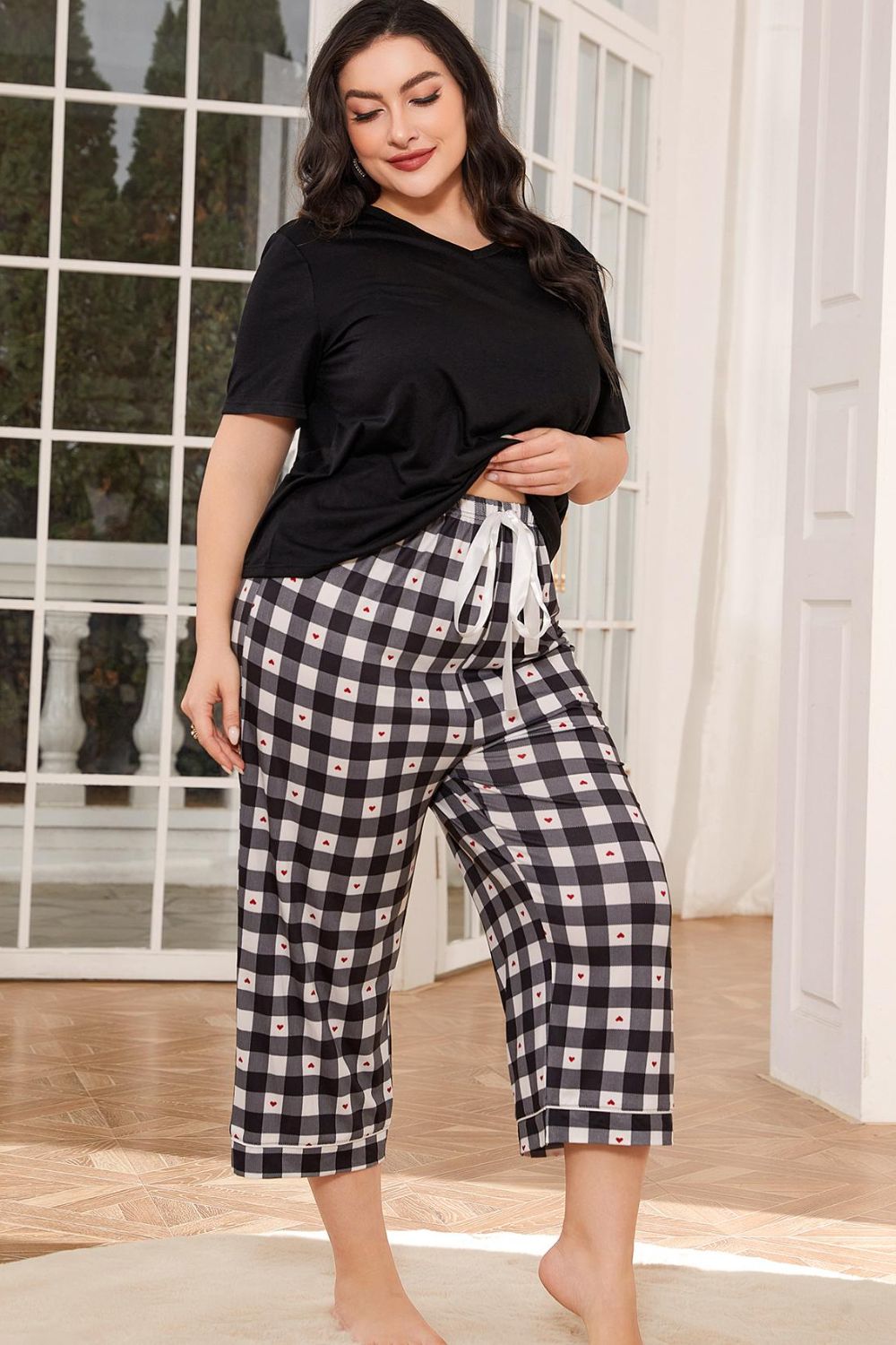 Plus size lounge set for women with black short sleeve top and black and white checkered pants with drawstring waist