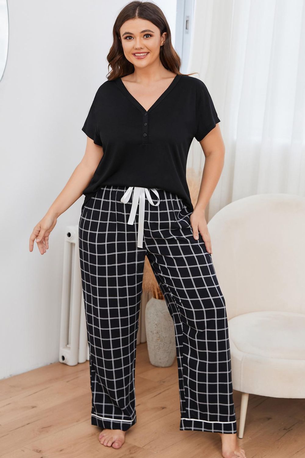plus size loungewear set featuring a black short sleeve top and black and white checkered drawstring pants