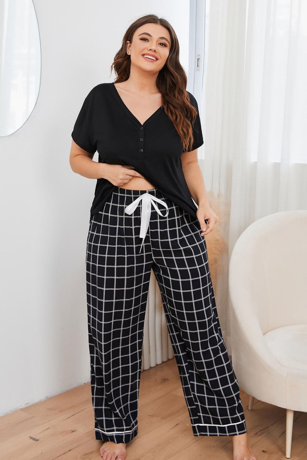 Plus size loungewear set with black short sleeve top and black and white checkered drawstring pants