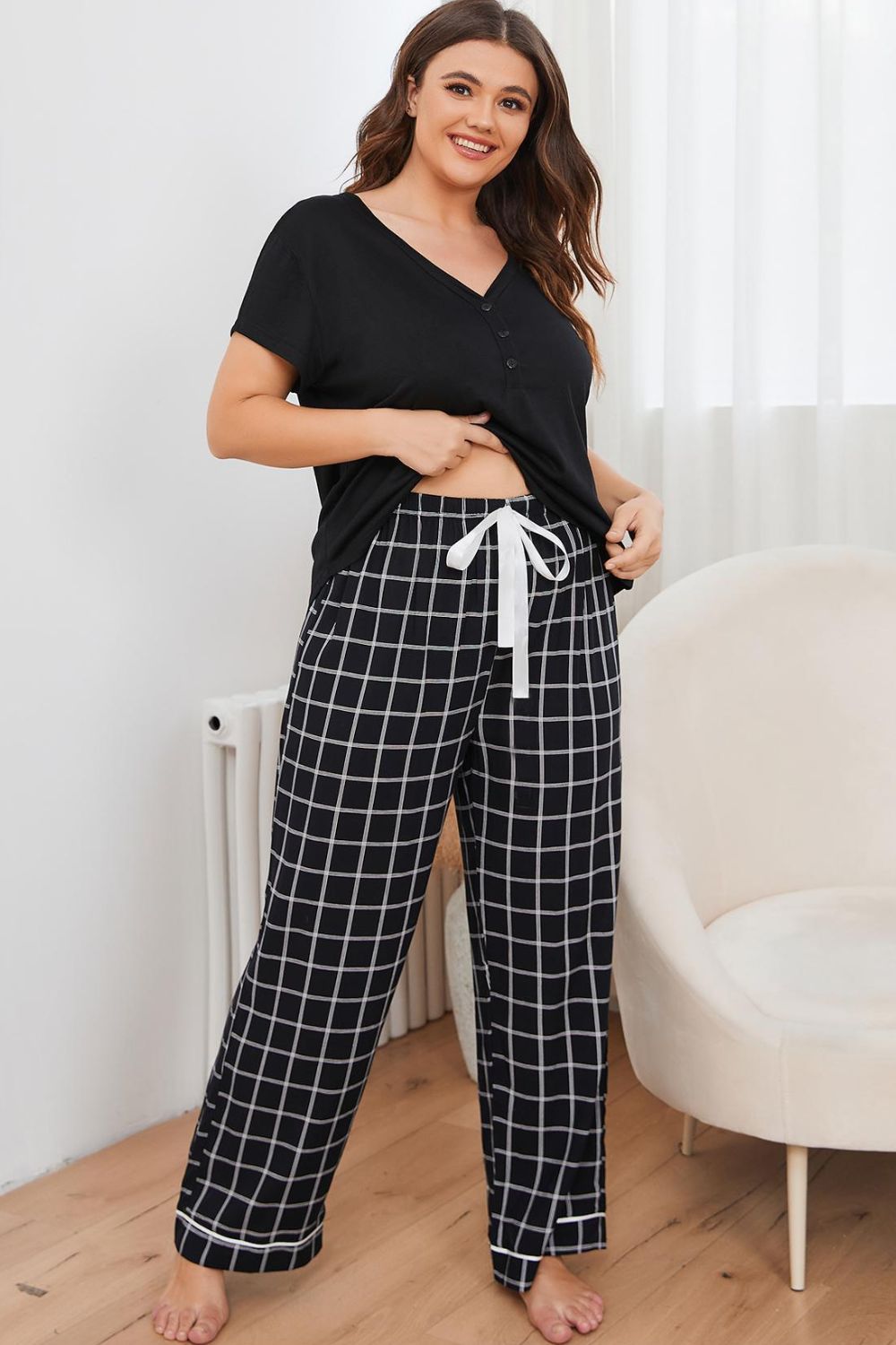 plus size loungewear set with black short sleeve top and checkered wide-leg pants with white drawstring