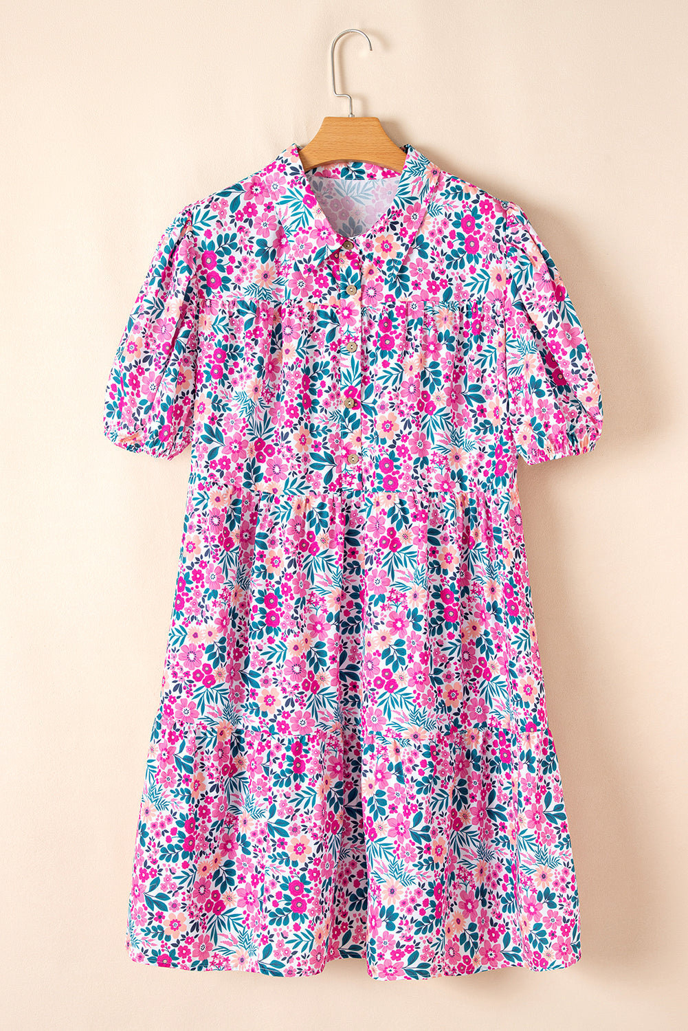 Pink plus size floral A-line mini dress with half button front and short puff sleeves hanging on hanger