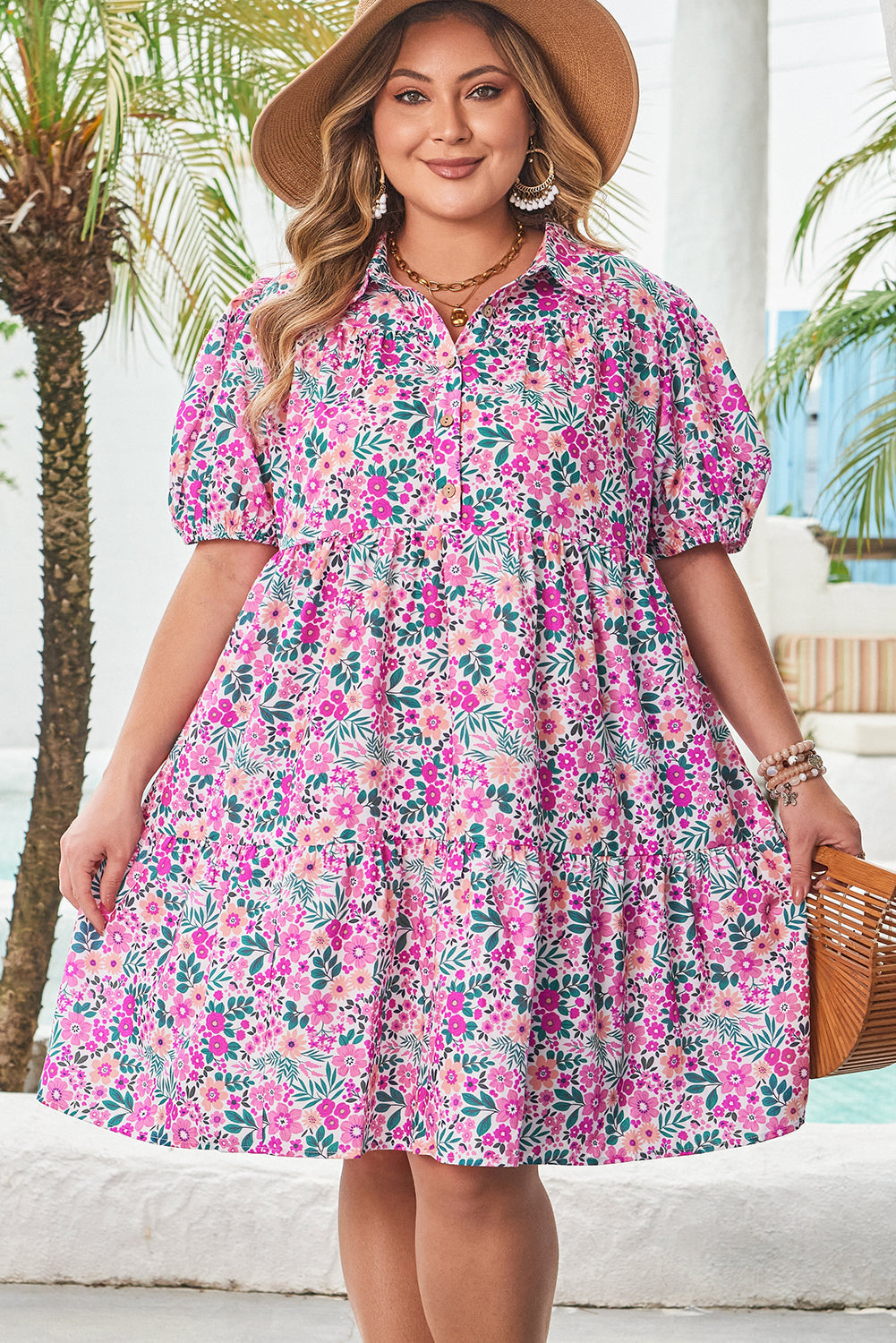 Plus size pink floral dress with puff sleeves and tiered skirt worn by a smiling woman with hat