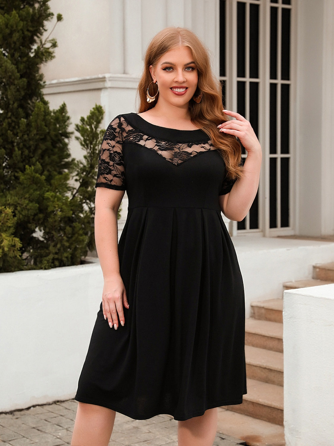 Trendsi plus size ruched dress in black with lace top and short sleeves worn outdoors