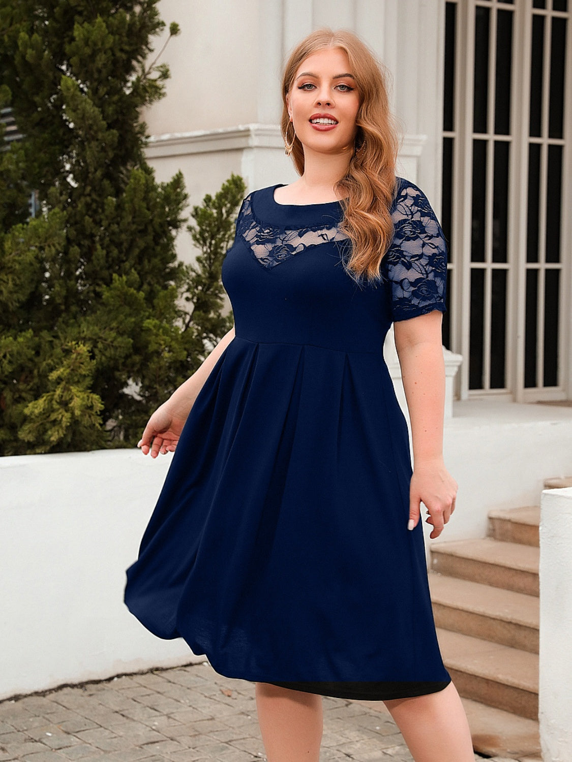 Trendsi plus size ruched dress in navy blue with lace sleeves and a flowy skirt