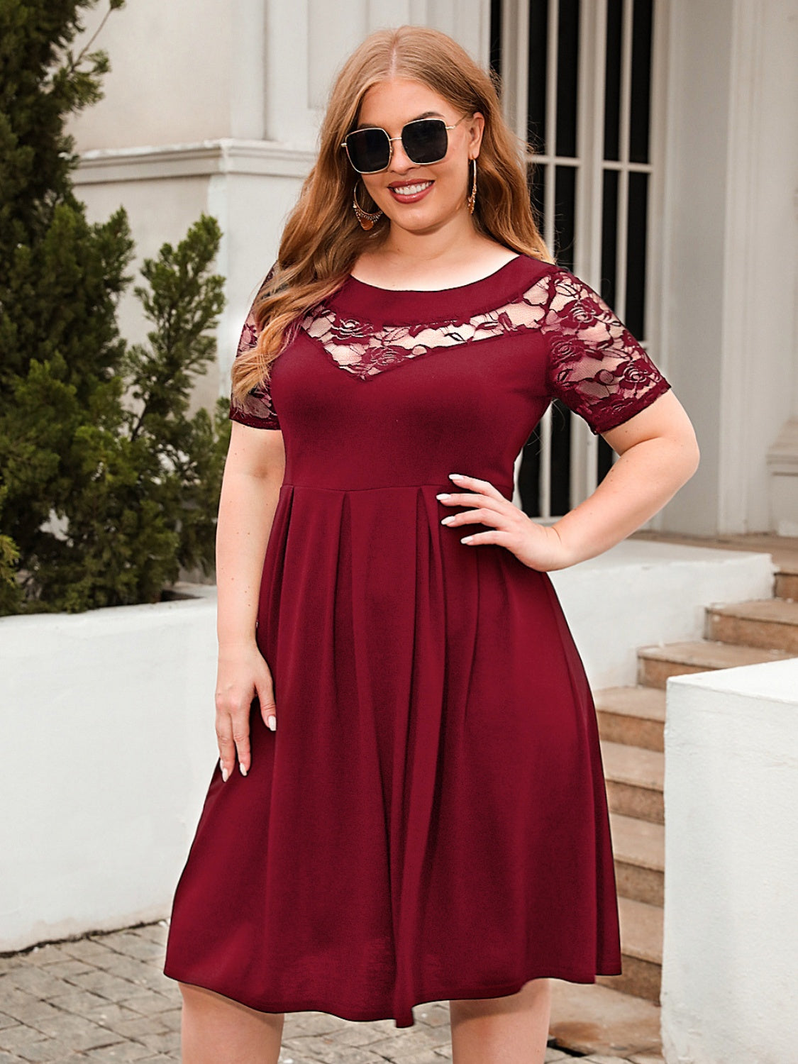 Trendsi plus size ruched dress in burgundy with lace sleeves and neckline worn with sunglasses