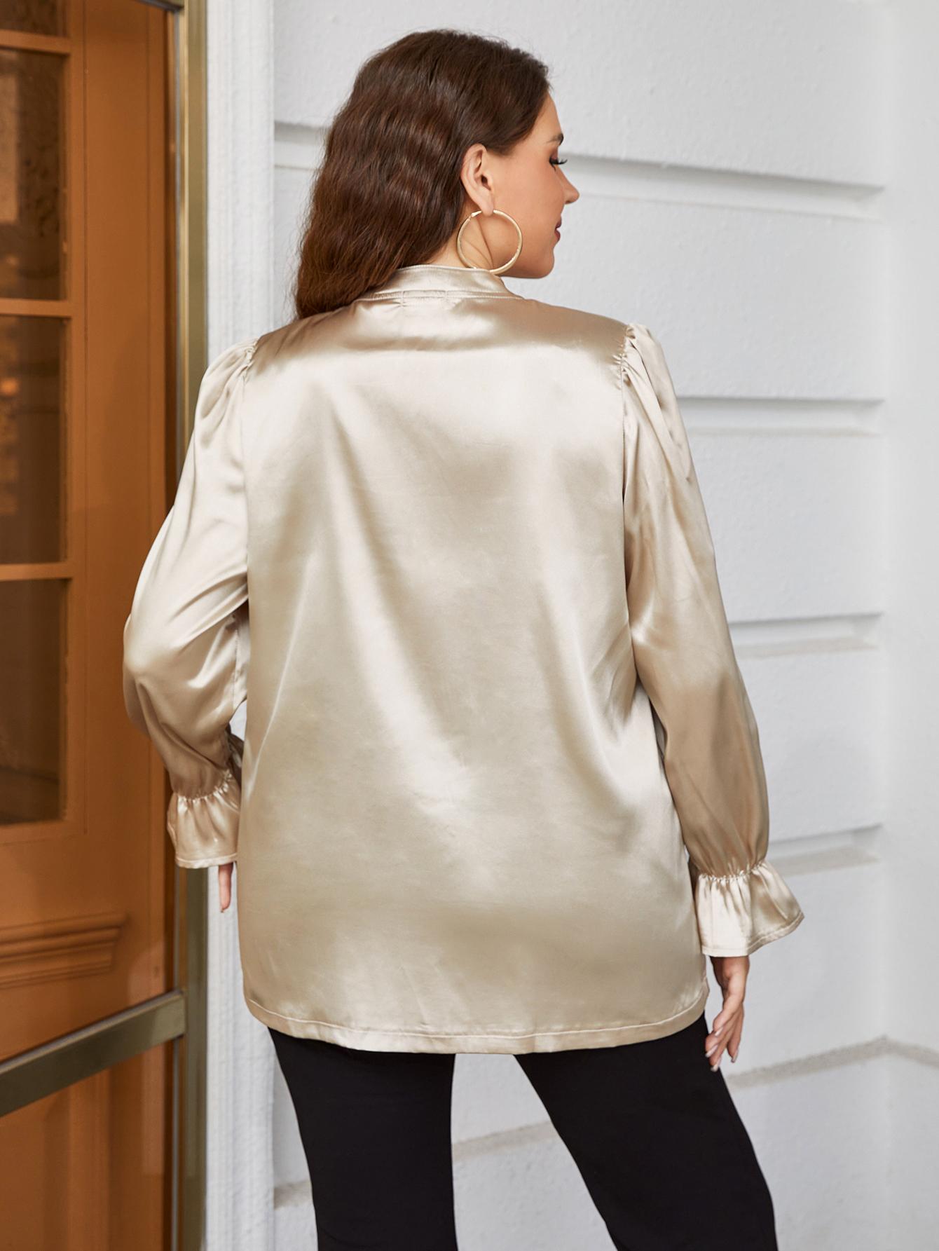Back view of a woman wearing a plus size satin blouse for women in champagne color with long sleeves