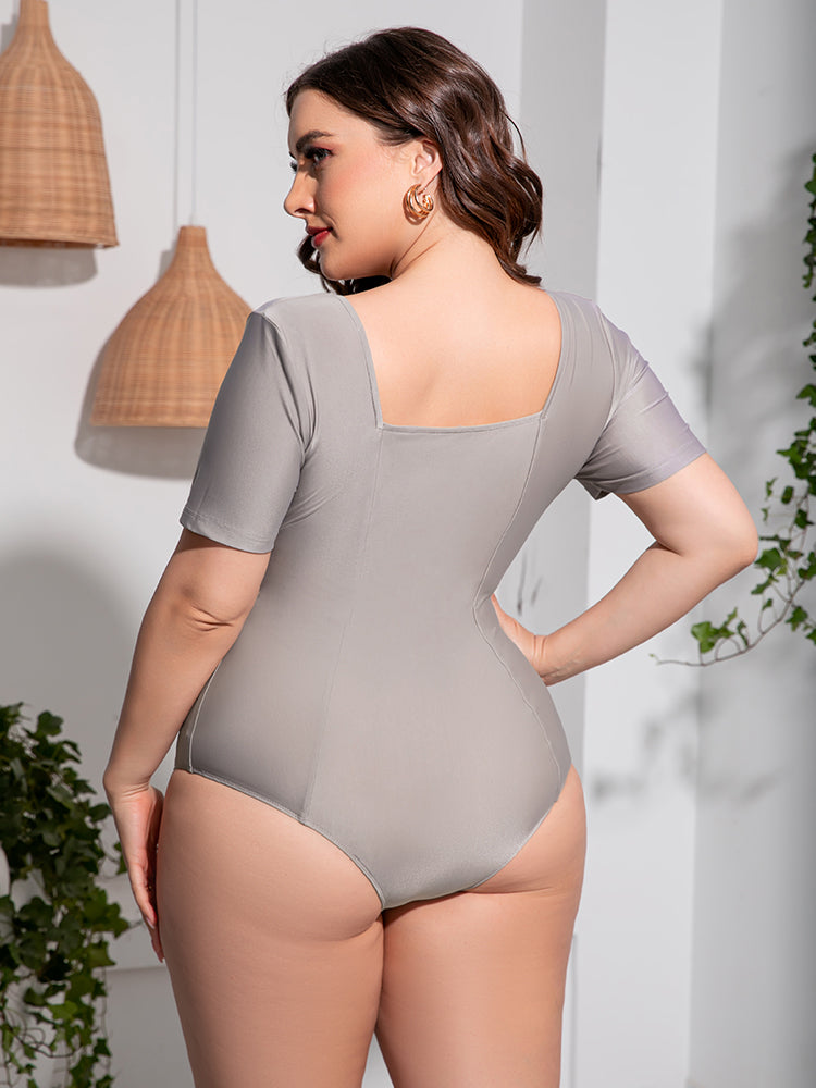 Plus size scoop neck swimsuit in light gray with short sleeves by Trendsi shown from back