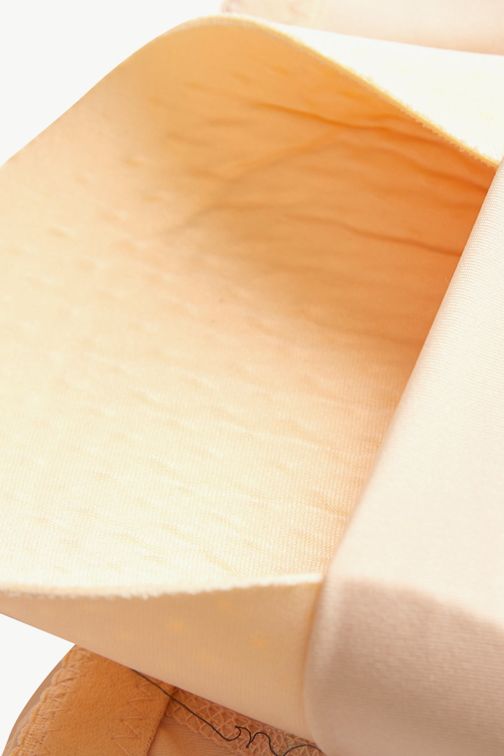 Close-up of beige plus size shaping shorts fabric showing stretch and texture detail