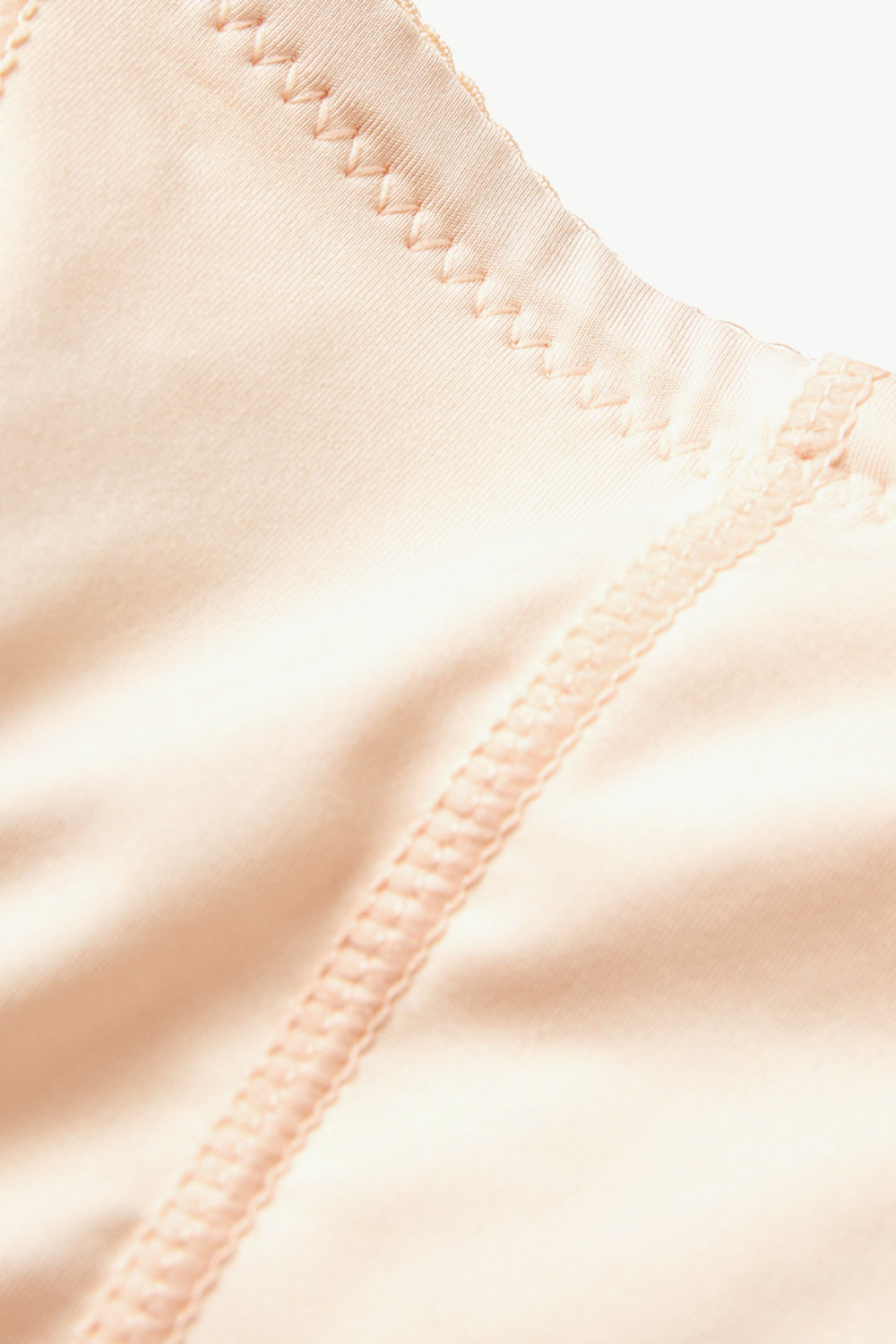 Close-up view of nude plus size shaping shorts fabric and stitching details by Trendsi