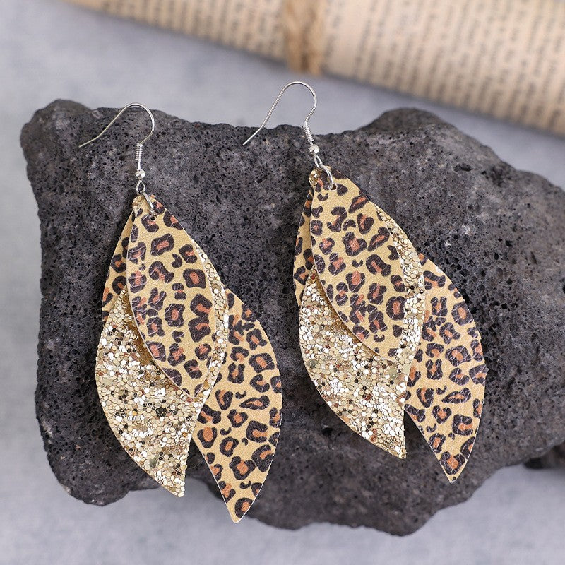 Leopard print and gold glitter layered PU leather statement earrings with silver hooks on black stone