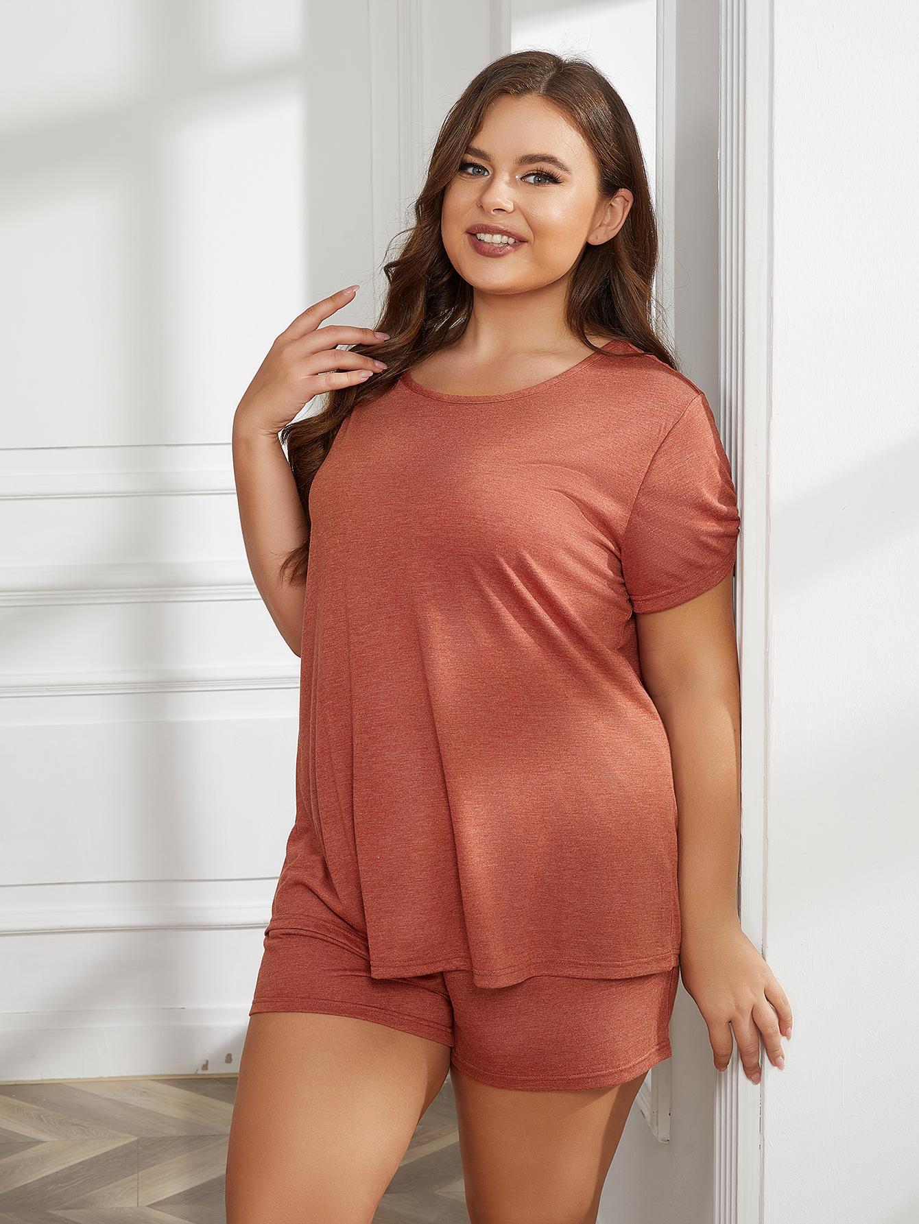 Plus size woman wearing round neck short sleeve plus size pajamas in rust color lounging indoors