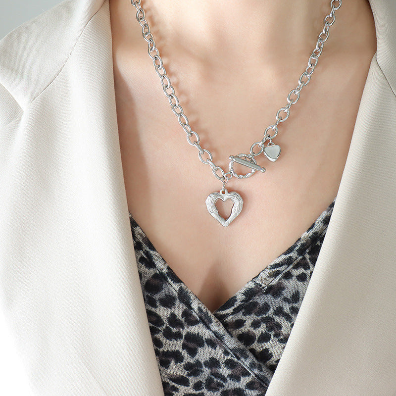 Trendsi titanium steel heart necklace with chunky chain and heart-shaped pendant worn with blazer
