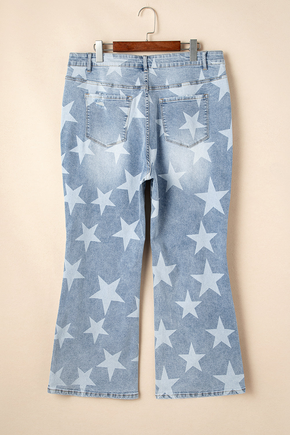Back view of kjplussizefashion sky blue distressed plus size jeans with white star print and flare legs