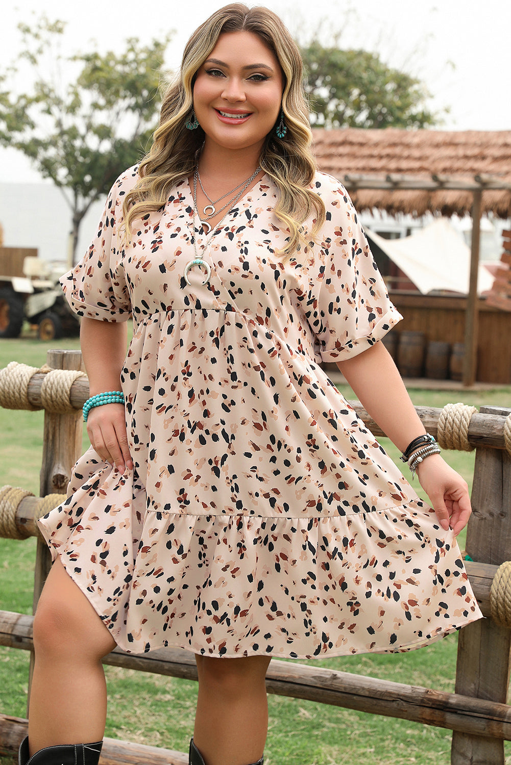 Plus size surplice neckline summer dress in beige with playful print and cuffed sleeves, perfect for warm weather.
