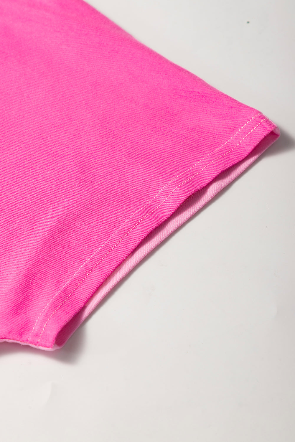 Bright pink short sleeve top for curvy women showing detailed sleeve stitching on soft fabric