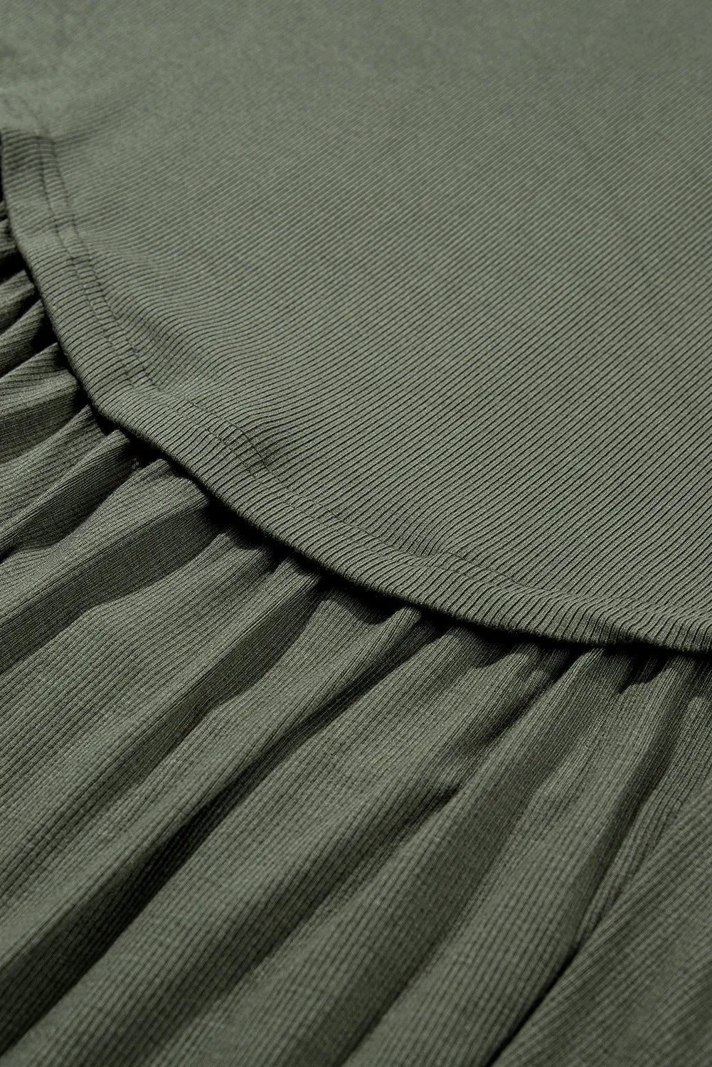 Close-up of olive green fabric texture and stitching on casual plus size long sleeve blouse