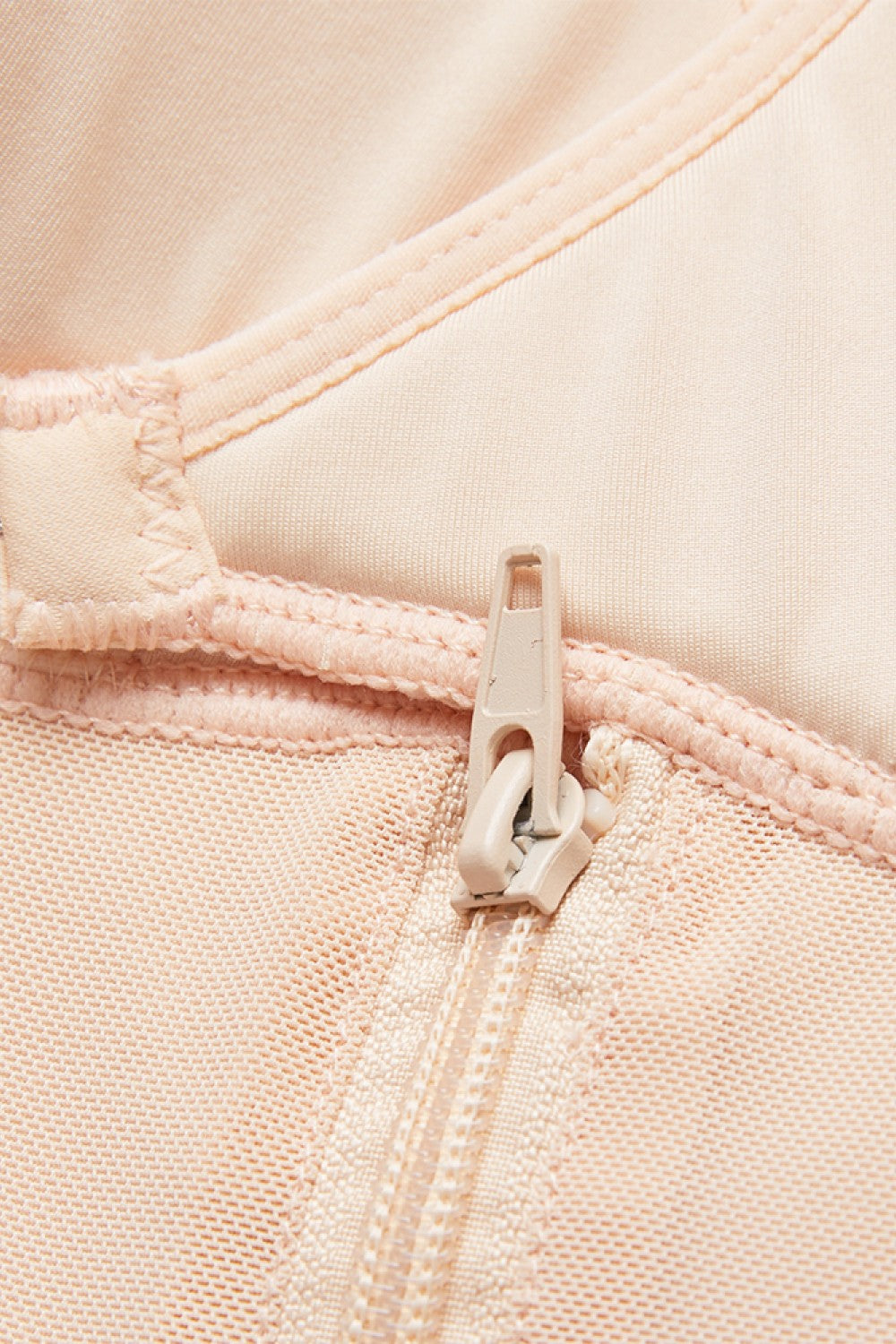 Close-up of beige full body plus size shapewear zipper and stitching details by Trendsi