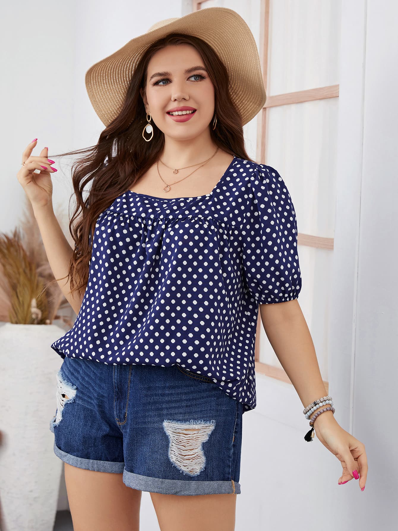 Trendsi honey polka dot blouse for women in navy blue with white dots paired with denim shorts and a sun hat