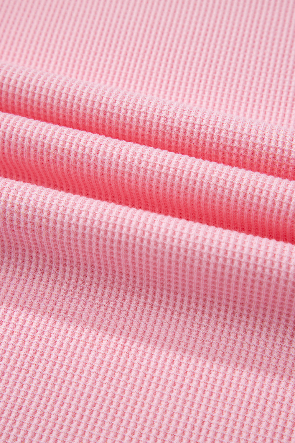 Close-up of pink stripe patchwork textured fabric for plus size summer shirt