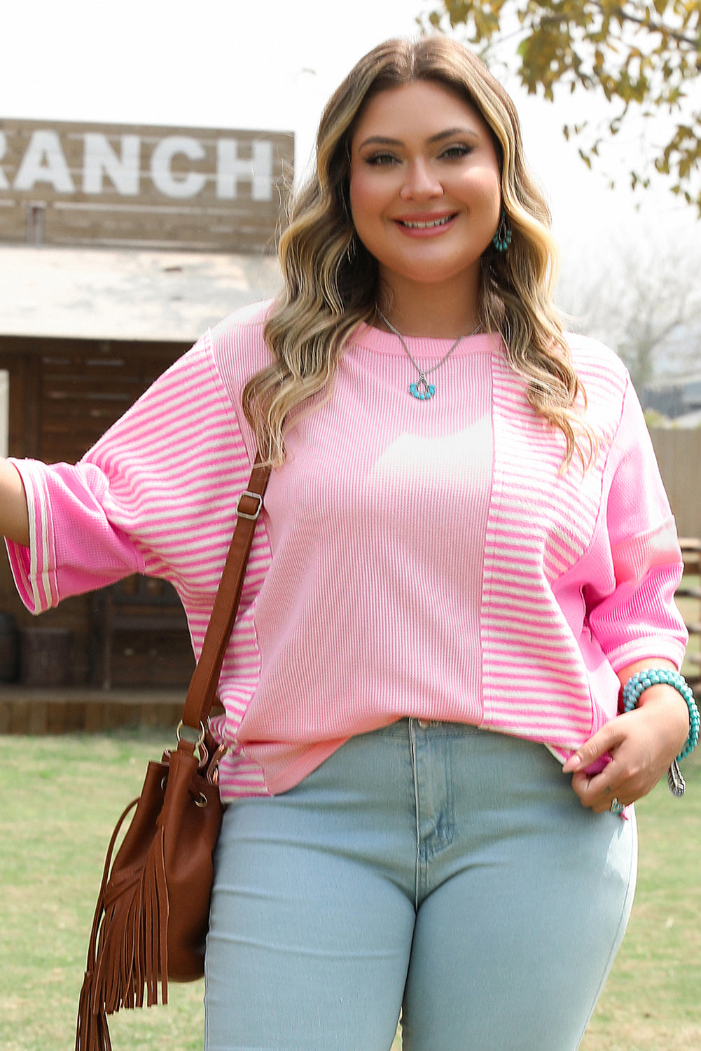 Plus size pink stripe patchwork summer shirt with relaxed fit and breathable fabric worn by smiling woman outdoors