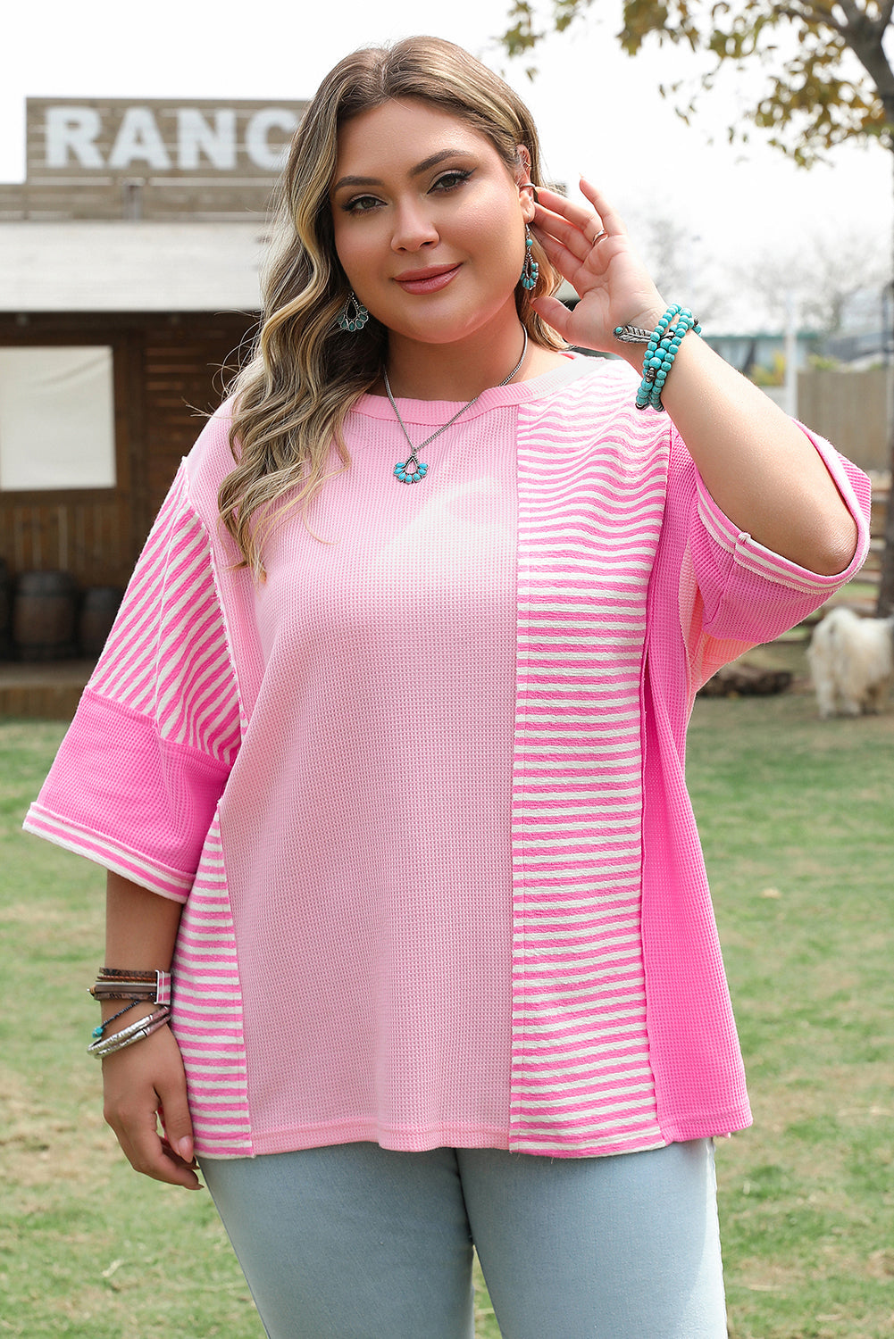 Plus size pink stripe patchwork summer shirt with relaxed fit and short sleeves worn outdoors