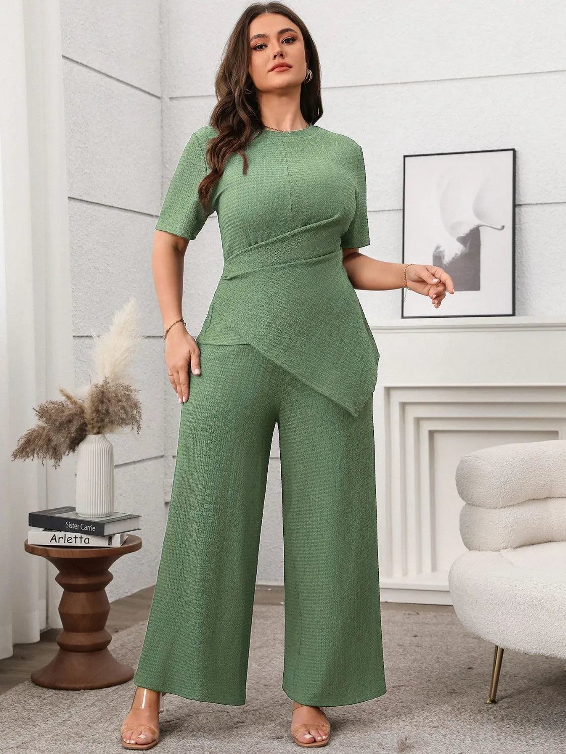 Plus size asymmetrical pants set in green textured fabric worn by woman with short sleeves and wide leg pants